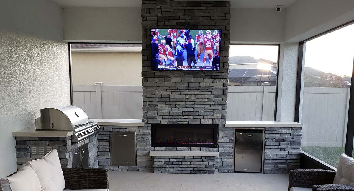 Concrete outdoor kitchen with stone fireplace