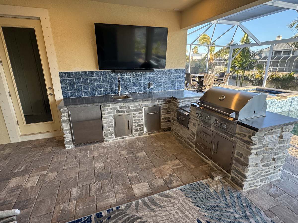 Concrete outdoor kitchen next to a pool