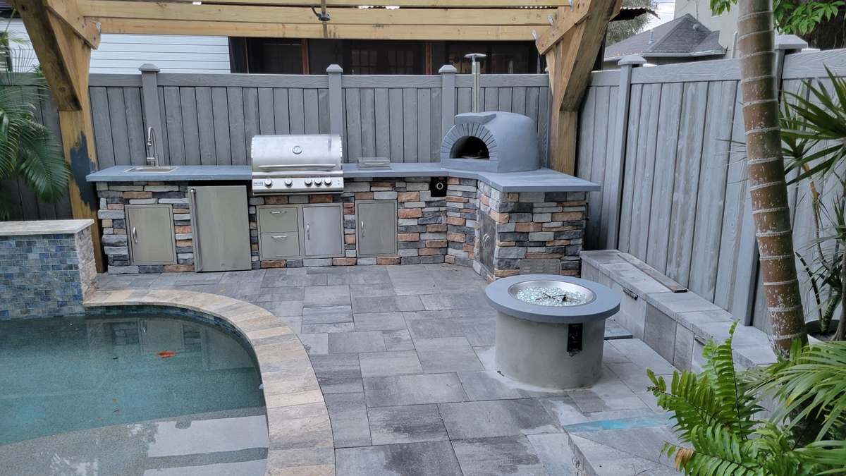Concrete outdoor kitchen by a curved pool